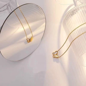 Gros plan du collier pendentif papillon doré avec une élégante incrustation en nacre blanche