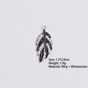 Detailed view of silver leaf pendant with black enamel inlay and sparkling rhinestones