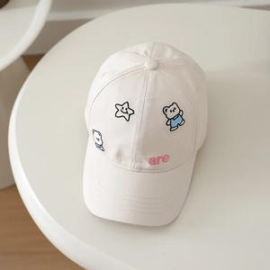 Detailed close-up of cartoon bear and star embroidery on beige cotton baseball cap