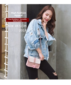 Pink and beige crossbody bag with double heart charms on outdoor model