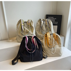 Primer plano de mochilas de nailon ligero con cordón ajustable y correas con letras diseño