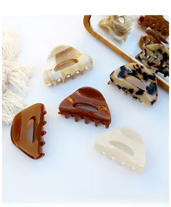Detail view of five assorted acetate hair claws in triangle shape and classic colors