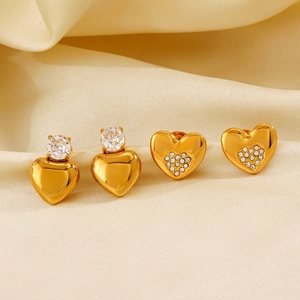 Orecchini a cuore placcati in oro 18K con zircone scintillante su sfondo in seta champagne