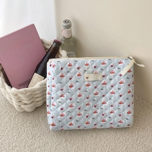 Close-up of quilted floral cosmetic bag with side handle and the jolly house label