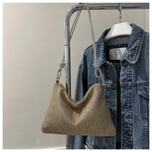 Close-up of golden rhinestone mesh chain bag with shimmering crystals on a hanger
