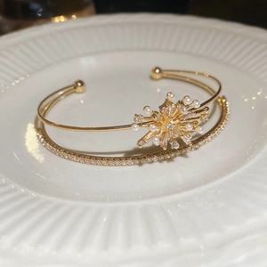 Close-up of golden double-layered bracelet featuring zircons and white pearls