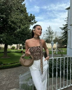 Outdoor shot of leopard print halter tube top paired with white high waist trousers
