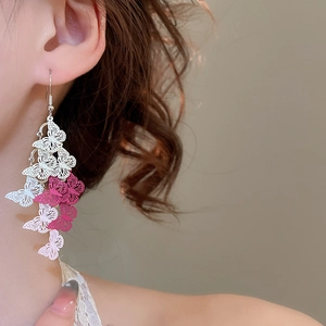 Close-up of long butterfly tassel earrings with blue and white gradient on model