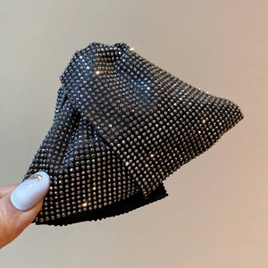 Close-up of a luxury triangular hair claw clip with shimmering silver rhinestones