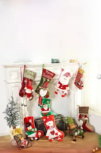 Detailed plush Christmas stockings with 3D Santa and reindeer hanging on a white fireplace