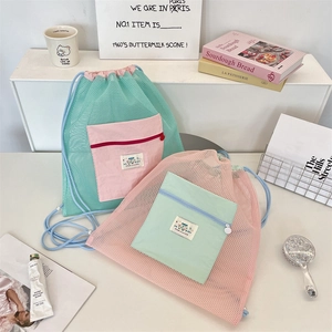 Détail de sacs à cordon en maille vert menthe et rose avec perles décoratives