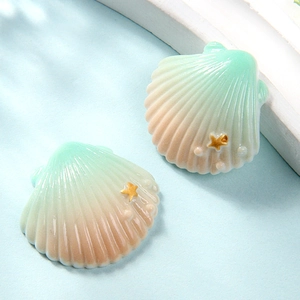 Detailed view of pink and green gradient resin shells with gold star accents for DIY crafts