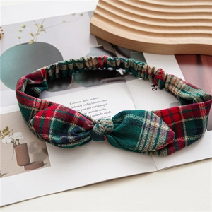 Detail of red and green plaid headband with rabbit ear knot on a magazine background