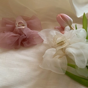 Detail of pink and white organza bow hair claws with elegant floral tulip accents
