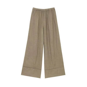 Detail of taupe wide-leg linen pants featuring intricate hollow embroidery at the hem