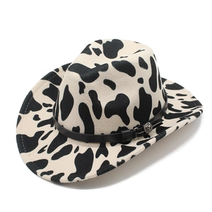 Detail of felt fedora hat with cow print pattern and leather band with silver floral buckle