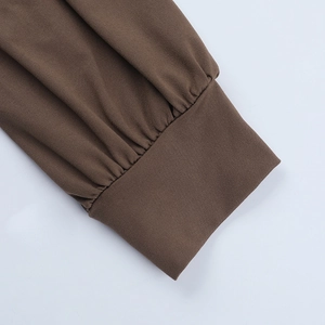 Gros plan détaillé des poignets en tricot marron foncé avec texture de couture de qualité