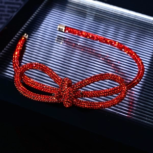 Detail view of sparkling red rhinestone bow headband with elegant crystal embellishments