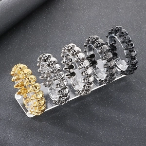 Hip hop skull bracelets in gold, silver, grey, and black on a display stand