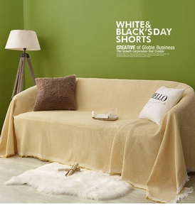 Detailed waffle weave texture on a beige sofa cover with elegant fringe edge decor