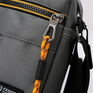 Men's gray oxford cloth crossbody bag with stylish yellow zipper and cord puller