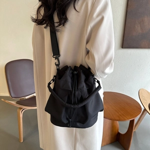 Mannequin portant un sac seau noir en nylon avec cordon et bandoulière amovible