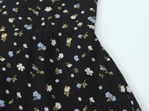 Close-up of floral print fabric with blue and white blossoms on black background
