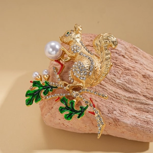 Vue macro de la broche écureuil dorée ornée de strass et de perles blanches