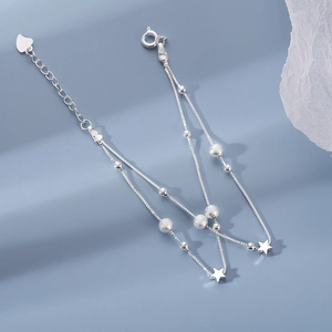 Elegant double-layer silver star bracelet with adjustable heart extension on blue backdrop