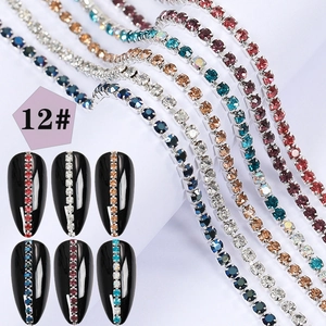 Detailed view of colorful rhinestone nail art chains with pearls on pointed fake nails