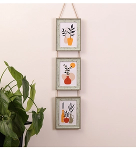 Close-up of three vertical hanging wooden frames with rustic hemp rope and plant art