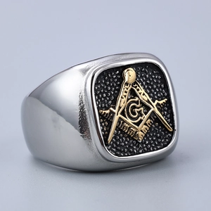 Macro detail of men's Masonic ring featuring a gold G symbol on silver stainless steel