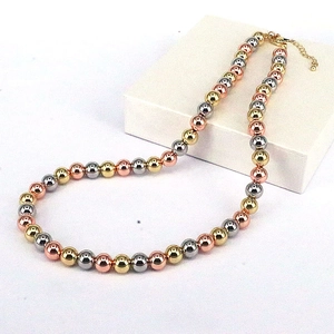 Close-up of tricolor beaded necklace with gold silver and rose gold metal spheres