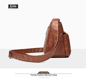 Side view of brown soft leather crossbody bag with small side pocket and textured finish