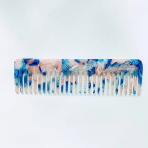 Close-up of pink and blue marble pattern wide-tooth acetate hair comb on white background