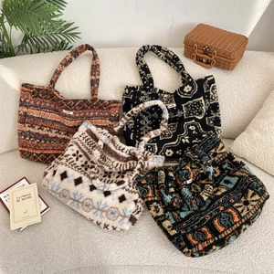 Macro view of four plush faux fur tote bags with geometric and vintage patterns