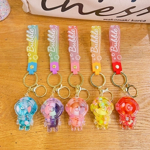 Five colorful astronaut liquid quicksand keychains with resin charms and silicone straps