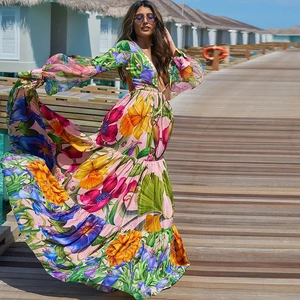 Vue dynamique d'une robe maxi à manches longues avec imprimé fleuri et décolleté en V profond