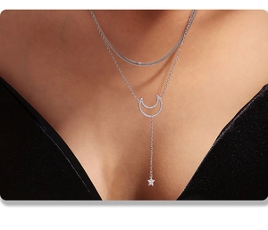 Detail of silver double-layer star and moon necklace with sparkling zircon on model