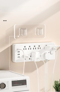 Close-up of transparent acrylic power strip holder with strong adhesive on a wall