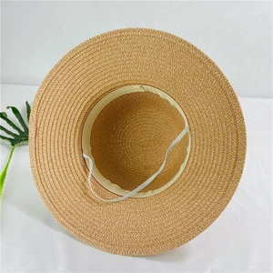 Detail of beige straw sun hat showing interior sweatband and elastic wind rope