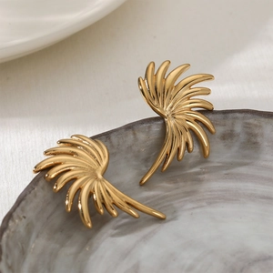 Boucles d'oreilles ailes dorées stylisées avec plumes radiales sur un plateau