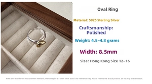 Detailed close-up of S925 sterling silver ring with a gold oval inlay on wooden box