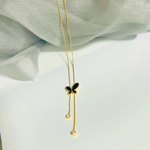 Gold titanium steel butterfly tassel necklace with zircon balls on white fabric