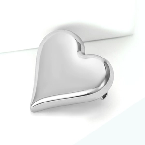 Detailed view of a minimalist silver heart brooch with a sleek polished finish for coats