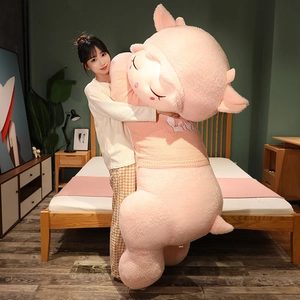 Close-up of extra large pink plush sheep wearing a pink knitted LOVE sweater in a bedroom