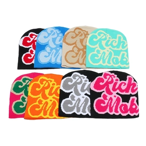 Multiple colorful knit beanies with Rich Mob jacquard lettering in 8 vibrant styles