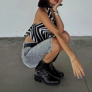 Detail der hellgrauen Denim-Shorts mit Aufschlag und Zebra-Print-Halterneck-Top
