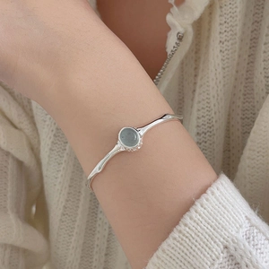 Minimalist S925 sterling silver open bangle featuring oval green gemstone on hand