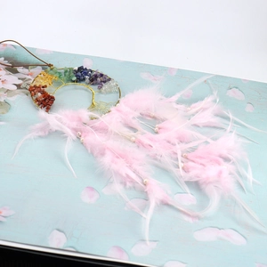 Macro detail of Tree of Life dream catcher featuring colorful stones and pink feathers